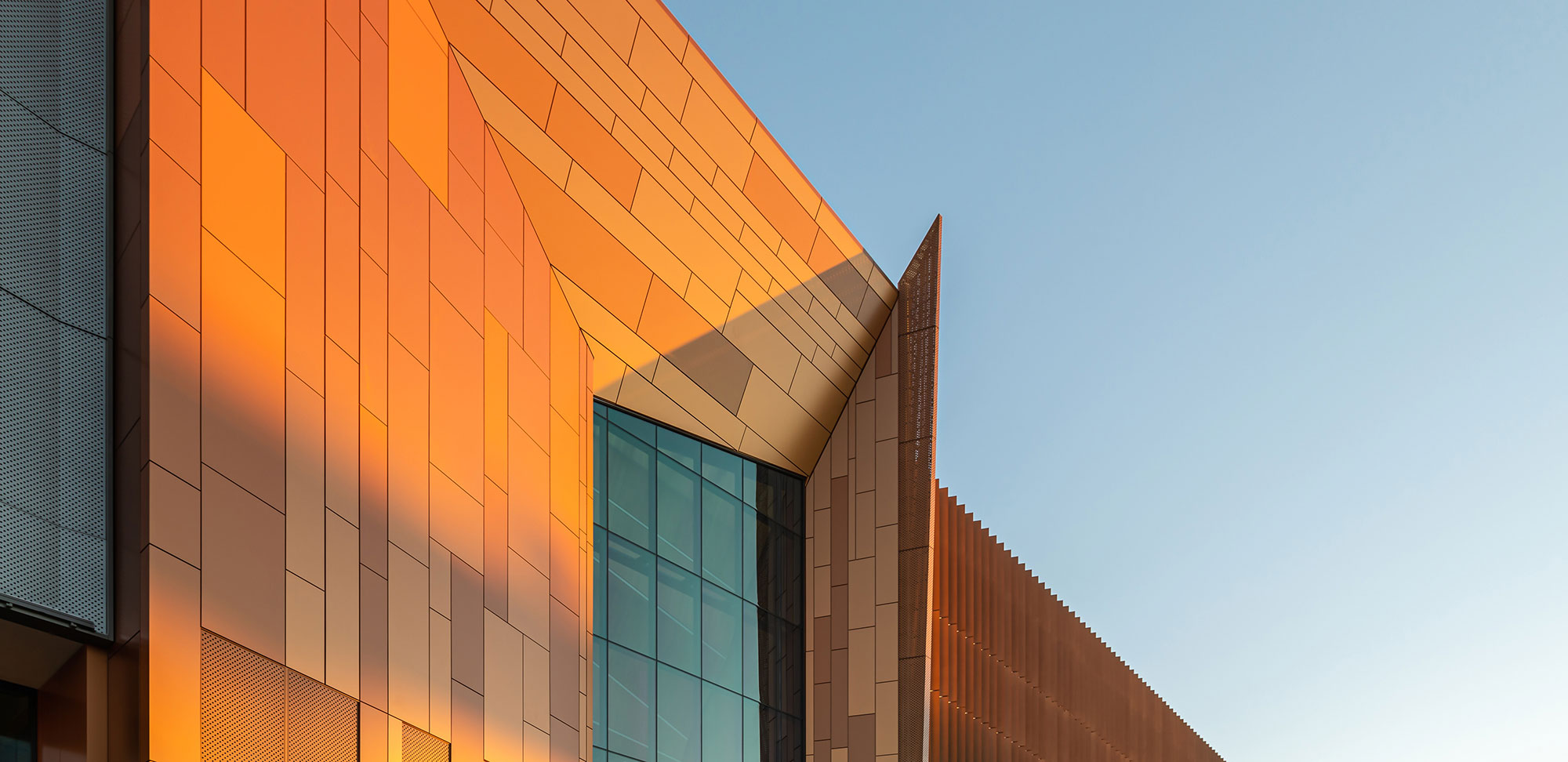 6-story grey and orange modern building with retail space