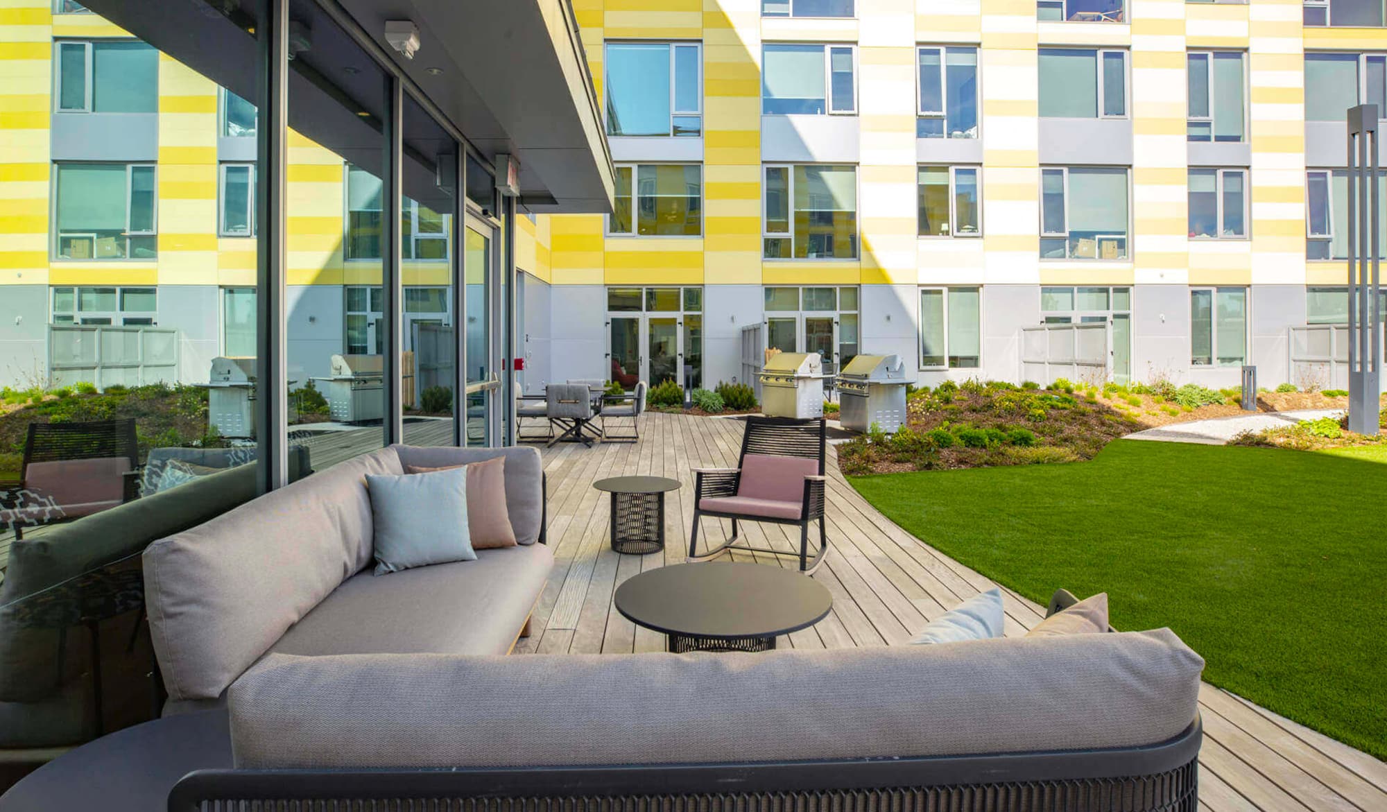 Outdoor lounge area with grills at The Harvey